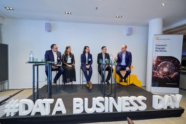 Austrian Data_Business_Day 2025 Fünf Personen sitzen auf einer Bühne hinter zwei hohen Tischen, davor große weiße Buchstaben mit der Aufschrift '#DATA BUSINESS DAY'. Rechts steht ein Banner mit den Worten 'Connect. Engage. Perform.' und einem Netzwerk-Globus-Motiv.