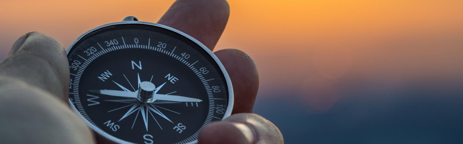 eine Hand hält einen Kompass