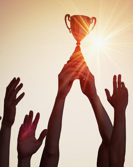 Hände greifen nach einem Pokal