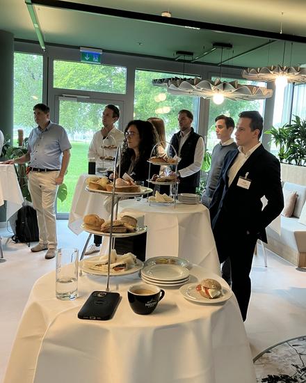 einige Personen, die an festlich geschmückten Stehtischen einem Vortrag zuhören einige Personen, die an festlich geschmückten Stehtischen einem Vortrag zuhören